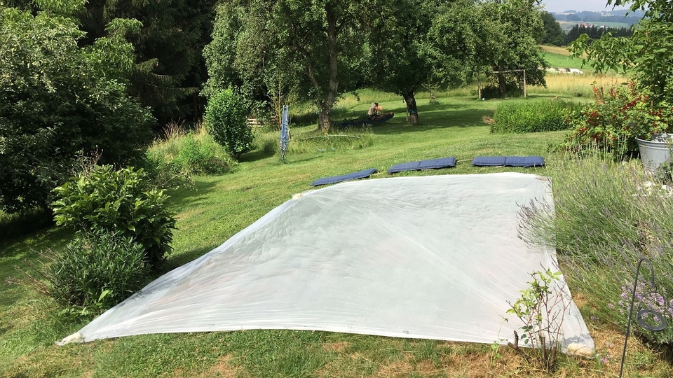 Der richtige Standort für einen selber gebauten Pool ermitteln und im Garten abstecken.