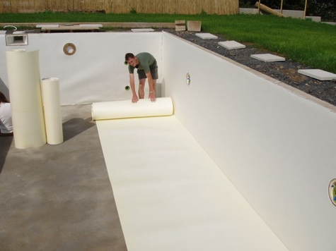 Verlegen von Isolier- und Polsterschaum für einen weichen Boden und Wände im selbstgebauten Pool.