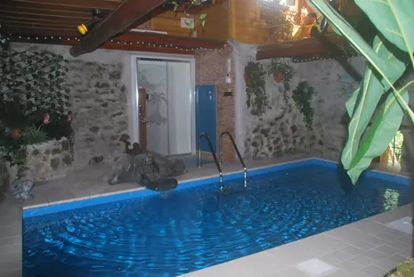 Pool in umgebauten Stall mit kleinem Wasserfall