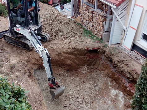 Minibagger macht den Aushub für den Pool im Garten